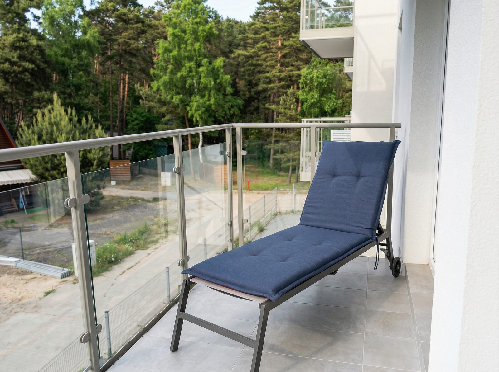 Balkon z leżakiem i widokiem na las